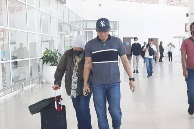 Orang yang diduga Kepala Bidang Cipta Karya Dinas PU Kalsel, Yulianti Erlinah (kiri), di Bandara Syamsudin Noor. Foto: Firman/ANTARA
