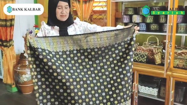 Masnita memperlihatkan kain tenun songket khas Kabupaten Sambas yang dibuatnya. Foto: Dok. Bank Kalbar