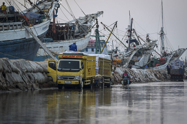 Seorang warga menggunakan kendaraan roda dua di tengah banjir rob di Pelabuhan Sunda Kelapa, Jakarta, Rabu (9/10/2024). Foto: Fauzan/ANTARA FOTO