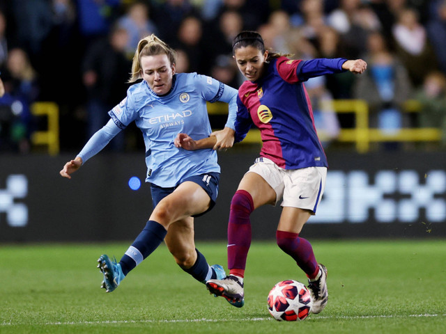 Pemain Barcelona Aitana Bonmati  berusaha melewati pemain Manchester City wanita  Lauren Hemp pada pertandingan Liga Champions wanita di Stadion Manchester City Akademi, Manchester, Inggris, Rabu (9/10/2024). Foto: Lee Smith/REUTERS 