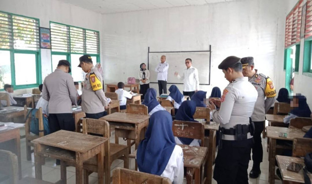 Polisi saat merazia handphone milik siswa di SMP Negeri 1 Gu, Buton Tengah.