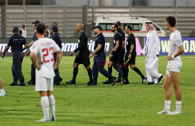 Petugas keamanan menjaga wasit Ahmed Al-Kaf usai laga Timnas Indonesia melawan Bahrain pada pertandingan Grup C Ronde 3 Kualifikasi Piala Dunia 2026 di Stadion Nasional Bahrain, Riffa, Bahrain, Kamis (10/10/2024). Foto: Hamad I Mohammed/REUTERS