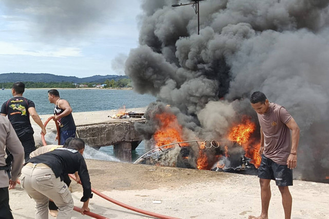 Petugas kepolisian bersama warga berusaha memadamkan api yang membakar speedboat milik Calon Gubernur Maluku Utara Benny Laos di Dermaga Pelabuhan Regional Bobong, Desa Bobong, Kabupaten Pulau Taliabu, Maluku Utara, Sabtu (12/10/2024). Foto: ANTARA FOTO/HO/Humas Polres Taliabu