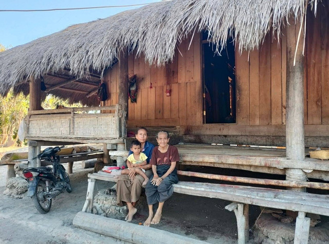 Dua wanita Sumba dan seorang anak di rumah tradisional Sumba. Sumber: shutterstock/xtine_surya