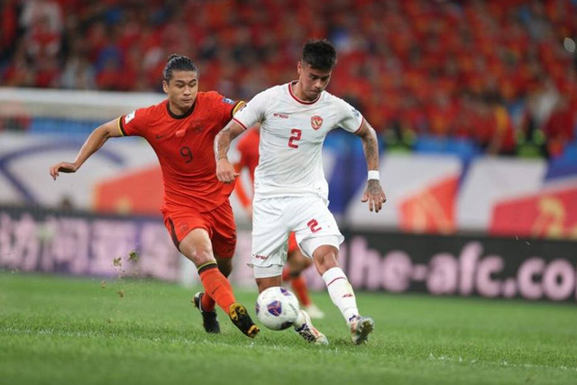 Pemain Timnas Indonesia Mees Hilgers berebut bola dengan pemain Timnas China Yuning Zhang pada pertandingan Grup C Ronde Ketiga Kualifikasi Piala Dunia 2026 di Stadion Sepak Bola Remaja Qingdao, Qingdao, China, Selasa (15/10/2024). Foto: AFC