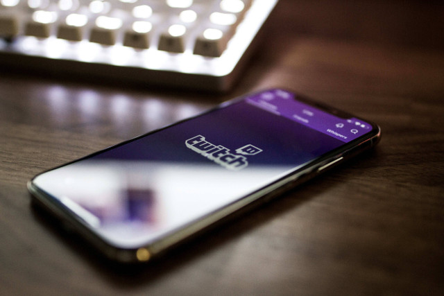 Aplikasi Twitch pada ponsel. Foto oleh Caspar Camille: https://unsplash.com/photos/space-gray-iphone-x-smartphone-turned-on-DrL-cwqD6tM?utm_content=creditCopyText&utm_medium=referral&utm_source=unsplash