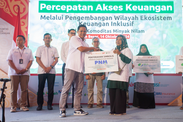 EVP Pengembangan dan Jasa Manajemen PNM Razaq Manan Ahmad saat menyerahkan produk pembiayaan Mekaar kepada petani minyak nilam di Desa Lhoong, Kecamatan Lhoong, Aceh Besar, Senin (14/10/2024). Foto: Dok. PNM