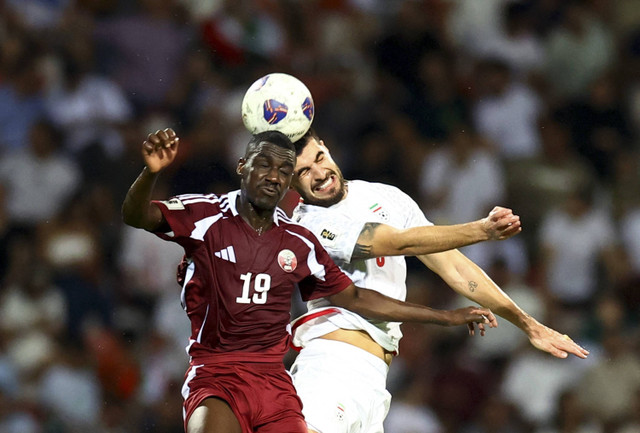 Pemain Qatar Almoez Ali beraksi dengan pemain Iran Saeid Ezatolahi pada pertandingan Kualifikasi Asia Babak Ketiga Grup A antara Iran melawan Qatar di Stadion Al-Rashid, Dubai, Uni Emirat Arab, Selasa (15/10/2024). Foto: Rula Rouhana/REUTERS