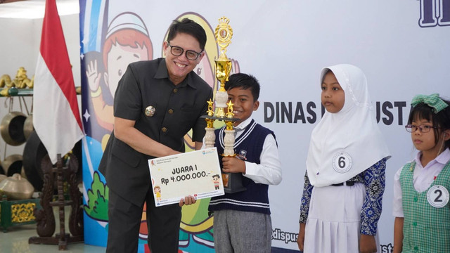 Pj Bupati Bojonegoro Adriyanto saat berikan piagam penghargaan kepada juara Lomba Bertutur di Pendopo Malowopati Pemkab Bojonegoro. Rabu (16/10/2024). (Aset: Istimewa)