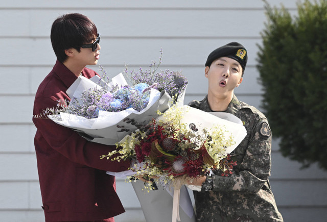 Anggota BTS, J-hope, memberi isyarat kepada para penggemar saat ia pergi setelah keluar dari wajib militer di luar pangkalan militer di Wonju pada 17 Oktober 2024. Foto: Jung Yeon-je/AFP