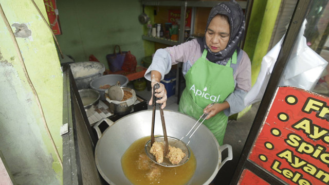 Lina Herlina, pemilik Papang Oo Chicken, menggoreng ayam menggunakan minyak padat Frybest dari Apical. Foto: Faiz Zulfikar/kumparan