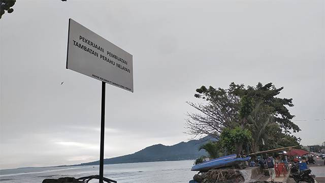 Papan pengumuman pembuatan tambatan perahu untuk nelayan yang dipasang oleh pengembang reklamasi Teluk Manado.