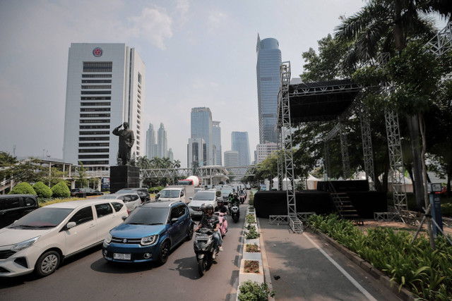 Sejumlah kendaraan melintas di sebelah panggung rakyat jelang pelantikan Prabowo-Gibran di Jalan Jenderal Sudirman, Jakarta, Sabtu (19/10/2024). Foto: Jamal Ramadhan/kumparan