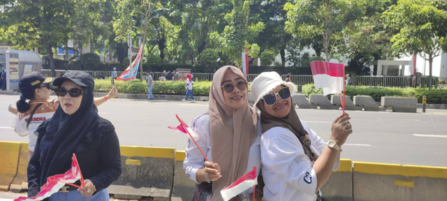 Warga asal Purwakarta dan Garut, Siti dan Endah, saat menanti kedatangan Prabowo-Gibran di Jalan Jenderal Sudirman, Minggu (20/10/2024). Foto: Rachmadi Rasyad/kumparan