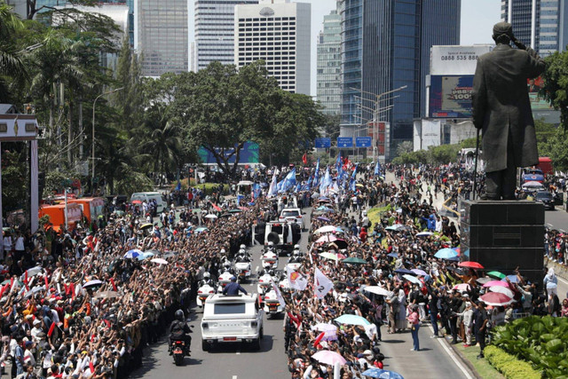 Presiden Prabowo Subianto menyapa warga dari atas kendaraan Maung Garuda di Jalan Jenderal Sudirman, Jakarta, Minggu (20/10/2024). Foto: Aditia Noviansyah/kumparan