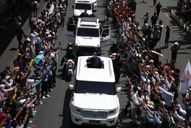 Presiden Prabowo Subianto menyapa warga dari atas kendaraan Maung Garuda di Jalan Jenderal Sudirman, Jakarta, Minggu (20/10/2024). Foto: Aditia Noviansyah/kumparan