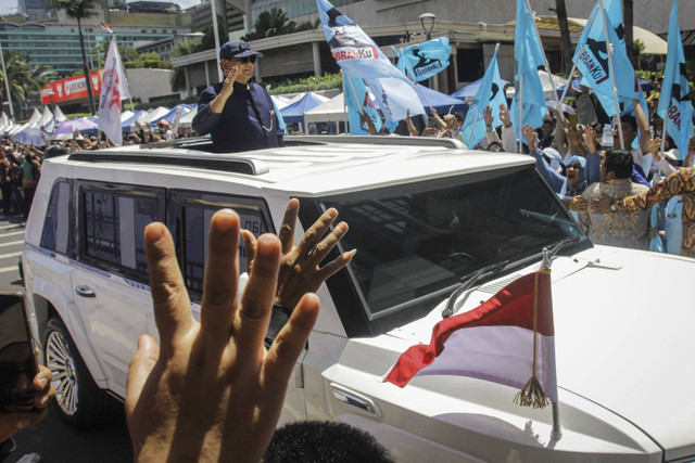 Presiden Prabowo Subianto berdiri menyapa warga dari mobil Pindad Maung Garuda di Jalan MH. Thamrin, Jakarta, Minggu (20/10/2024). Foto: Sigid Kurniawan/ANTARA FOTO 