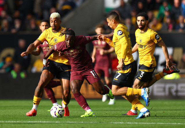 Jeremy Doku diadang Mario Lemina, Andre Neto, dan Rayan Ait-Nouri saat Wolverhampton Wanderers vs Manchester City dalam laga pekan kedelapan Liga Inggris 2024/25 di Stadion Molineux, Minggu (20/10) malam WIB. Foto: REUTERS/Molly Darlington