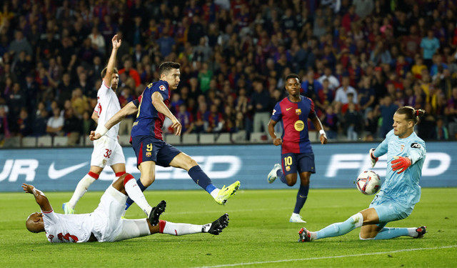 Orjan Nyland memblok sepakan Robert Lewandowski saat Barcelona vs Sevilla dalam laga pekan ke-10 Liga Spanyol 2024/25 di Estadi Olimpic Lluis Companys, Senin (21/10) dini hari WIB. Foto: REUTERS/Albert Gea