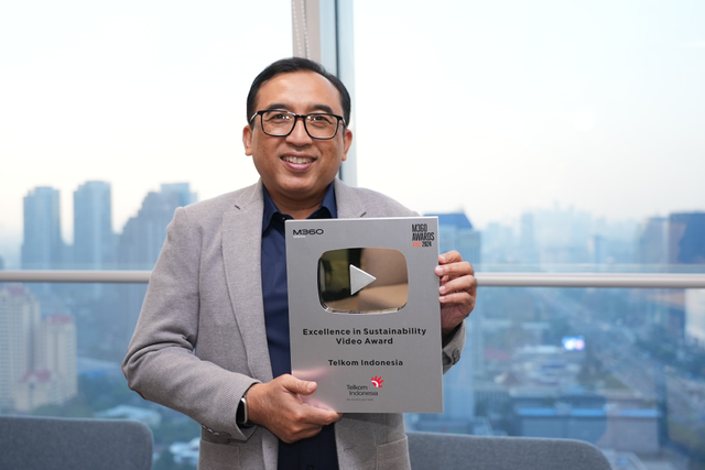 VP Corporate Communication Telkom Andri Herawan Sasoko menunjukkan trofi M360 Digital Nations Awards 2024. Melalui video “Water Management System: Constructing a Sustainable Tomorrow”, Telkom memenangkan kategori Excellence in Sustainability Video Award. Foto: Dok. Telkom