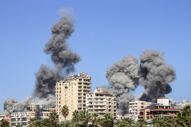 Gumpalan asap mengepul setelah serangan udara Israel di sebuah lingkungan di kota Tyre, Lebanon selatan, Rabu (23/10/2024). Foto: KAWNAT HAJU/AFP