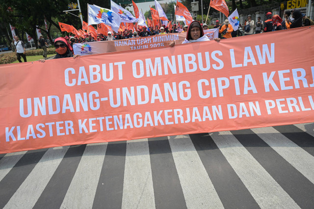 Sejumlah buruh berjalan sambil membentangkan spanduk saat berunjuk rasa di kawasan Patung Kuda, Jakarta, Kamis (24/10/2024). Foto: ANTARA FOTO/Fauzan