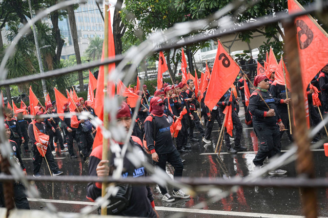 Sejumlah buruh berjalan sambil membentangkan spanduk saat berunjuk rasa di kawasan Patung Kuda, Jakarta, Kamis (24/10/2024). Foto: ANTARA FOTO/Fauzan