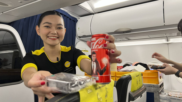 Salah satu awak kabin Scoot, maskapai low-cost carrier asal Singapura, saat melayani penumpang. Foto: Gadi Kurniawan Makitan/kumparan