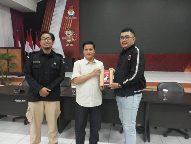 Ketua Divisi Sosialisasi Pendidikan Pemilih dan Partisipasi Masyarakat KPU Jabar, Hedi Ardia, secara simbolis menyerahkan alat peraga kampanye kepada perwakilan tim pasangan calon di Aula Setia Permana, Kantor KPU Jabar. Foto: Istimewa