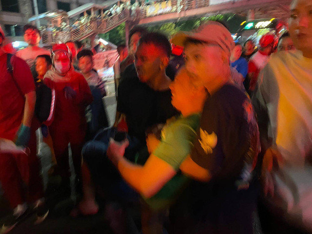 Warga menolong salah satu korban kebakaran di Mampang, Jakarta Selatan pada Kamis (24/10/2024) malam. Foto: Abid Raihan/kumparan