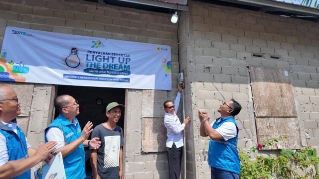 Simbolis penyalaan listrik Program Light Up The Dream oleh Kepala Desa Rasau Jaya Tiga, Tukiman (kedua dari kanan), Senior Manager Niaga dan Manajemen Pelanggan, Albert Safaria (kedua dari kiri) beserta manajemen PLN UP3 Pontianak. Foto: Dok. PLN Kalbar