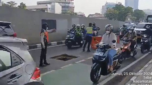 Sejumlah kendaraan melintas di dekat Gorong-Gorong yang terbuka akibat dicuri oleh orang di Jalan MT Haryono, Jakarta, Jumat (25/10/2024). Foto: X/ @TMCPoldaMetro