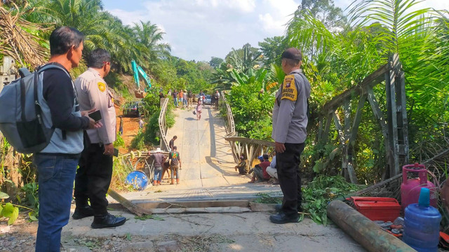 Personel Polsek Sayan saat melihat jembatan yang roboh usai dilalui tronton. Foto: Yus Rizal/Hi!Pontianak