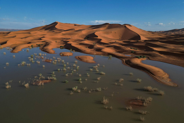 Foto udara menunjukkan bukit pasir yang sebagian tertutup oleh banjir di Merzouga, Maroko, pada 24 Oktober 2024. Foto: Stelios Misinas/REUTERS