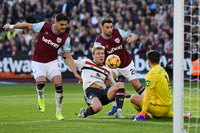 Pemain West Ham United Lukasz Fabianski berebut bola dengan pemain Manchester United Rasmus Hojlund pada pertandingan Liga Inggris di Stadion London, London, Inggris, Minggu (27/10/2024). Foto: Tony O Brien/REUTERS