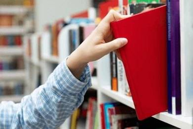 Photo by Shutterstock: https://www.shutterstock.com/id/image-photo/female-hand-pulling-book-bookshelf-public-2458178547