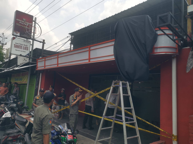 Polisi dan Satpol PP menyegel sebuah outlet penjual minuman keras di wilayah Kota Yogyakarta. Foto: Polresta Yogyakarta