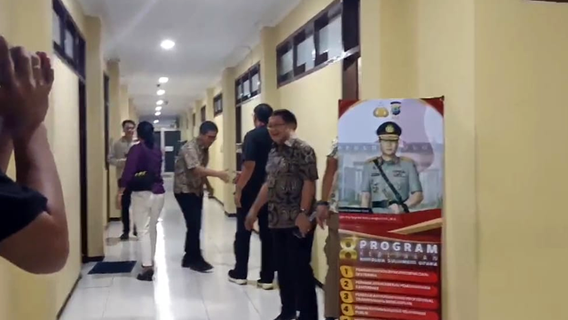 Penjabat Bupati Minahasa Tenggara, Denny Mangala, saat ke luar dari ruangan nomor 8 penyidik Subdit Tipikor Polda Sulawesi Utara, Jumat (1/11) malam. (foto: febry kodongan)