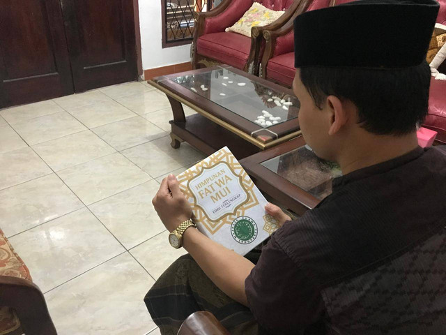 Seseorang sedang Membaca Buku Fatwa MUI I Dok: Pribadi, Muhammad Abdul Aziz 