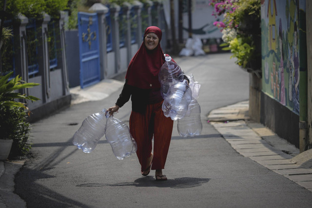 Membawa Sampah Galon: Warga membawa galon bekas untuk disetorkan ke Bank Sampah 68. Foto: Jamal Ramadhan/kumparan