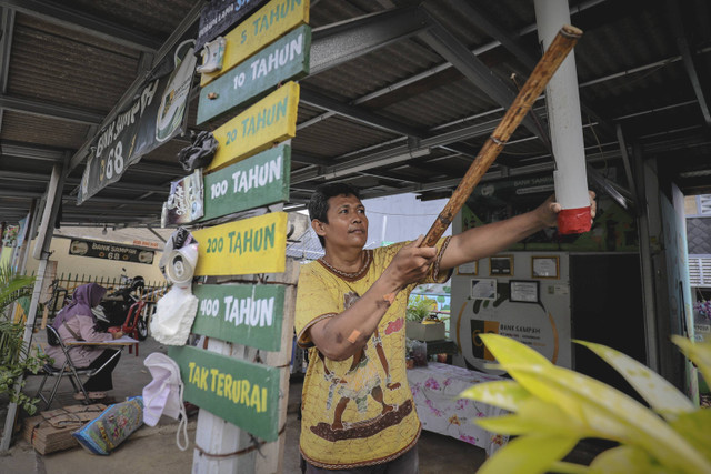 Ajak Warga: Mas Pri mengetuk pentungan saat mengajak warga untuk menabung sampahnya di Bank Sampah 68, Kelurahan Kebagusan, Jakarta Selatan. Foto: Jamal Ramadhan/kumparan