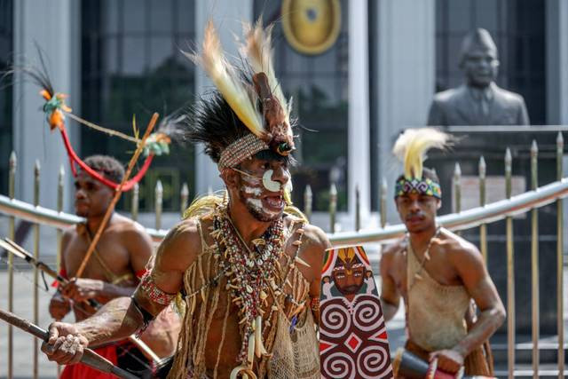 Perwakilan masyarakat suku Awyu Papua dan suku Moi melakukan aksi dengan cara menari dan melakukan ritual di depan Gedung Mahkamah Agung, Jakarta, Senin (27/5/2024).  Foto: Bay Ismoyo/AFP