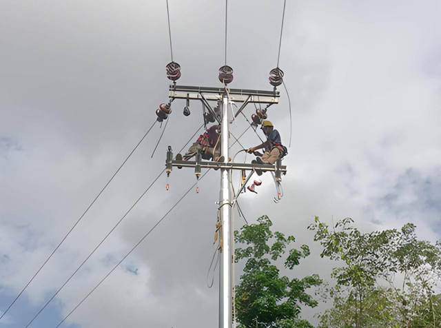 Petugas PLN sedang melakukan penyambungan jumper SUTM pada  jaringan listrik Desa Pengkadan Sungai Rupa, Kecamatan Dedai, Kabupaten Sintang. Foto: Dok. PLN Kalbar