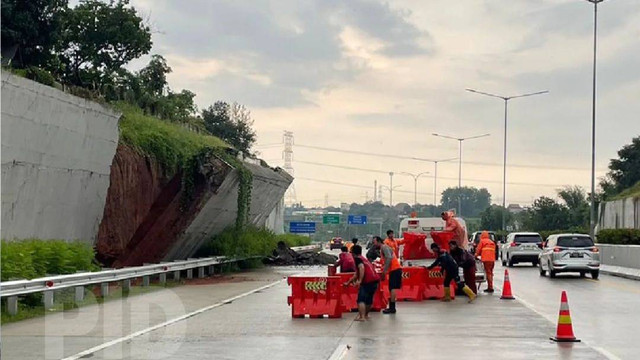 Petugas menutup sebagian jalur Tol Cinere - Serpong Jaya Akibat longsor yang disebabkan hujan deras pada Sabtu (2/11). Foto: Instagram/@korlantaspolri.ntmc