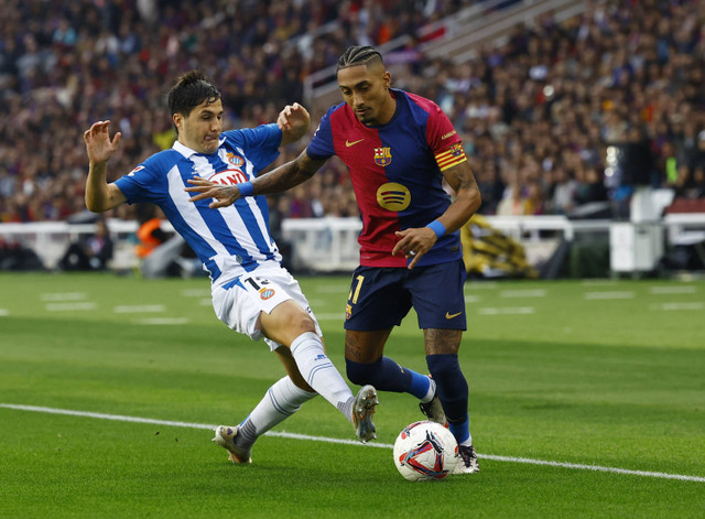 Raphinha dari FC Barcelona beraksi dengan pemain RCD Espanyol Alvaro Tejero pada pertandingan LaLiga antara FC Barcelona melawan Espanyol di Estadi Olimpic Lluis Companys, Barcelona, Spanyol, Minggu (3/11/2024). Foto: Albert Gea/REUTERS 