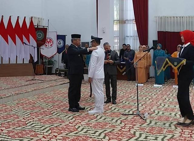 Pj Gubernur Kalbar, Harisson menyerahkan tanda jabatan kepada Pj Wali Kota Pontianak, Edi Suryanto. Foto: Alycia Tracy Nabila/Hi!Pontianak