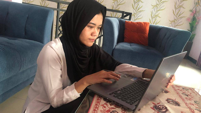 Potret Mahasiswa yang sedang Menulis opini dan publikasi tentang Relevansi dan Tantangan Ekonomi Islam di Era Modern (sumber: Ichwan, foto diambil dengan gadget di ruang tamu rumah pada pukul 13.48 dengan ukuran 16:9)