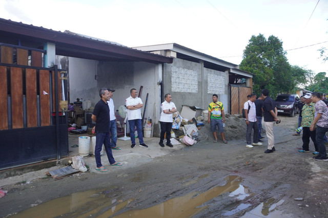 AJP dan ASLI saat mengecek jalan rusak di komplek perumahan di Kendari.