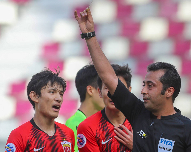 Para pemain SIPG berdebat dengan wasit Iran Mooud Bonyadifard setelah dia memberikan penalti pada pertandingan sepak bola grup H Liga Champions AFC antara Shanghai SIPG Tiongkok dan Jeonbuk Hyundai Korea pada 4 Desember 2020. Foto: Karim Jaafar / AFP