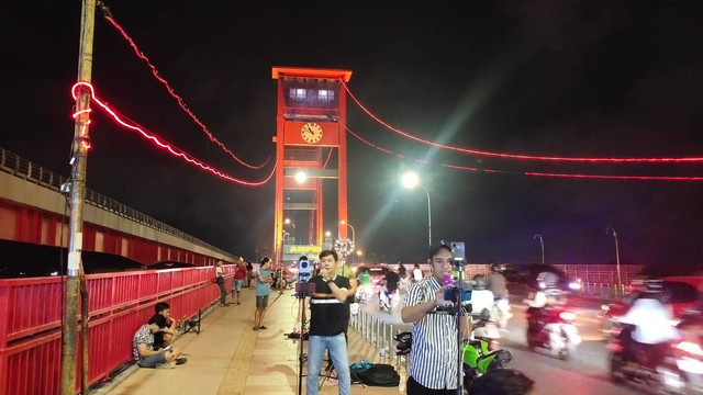 Para anak muda di Palembang saat sedang mencari cuan lewat TikTok dengan background Jembatan Ampera, Foto : Abdullah Toriq/Urbanid